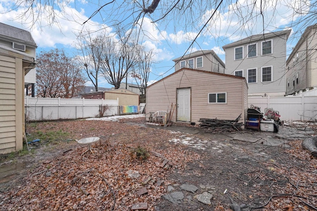 rear view of house with a fenced backyard and an outdoor structure