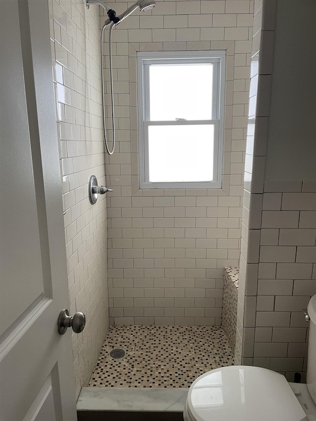 bathroom with toilet and tiled shower