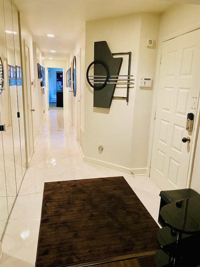 hall with light tile patterned floors and baseboards