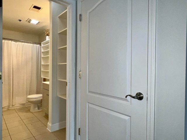 bathroom with toilet and tile patterned floors