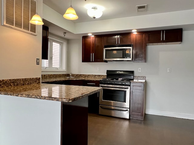 kitchen with stainless steel appliances, pendant lighting, sink, dark stone countertops, and kitchen peninsula