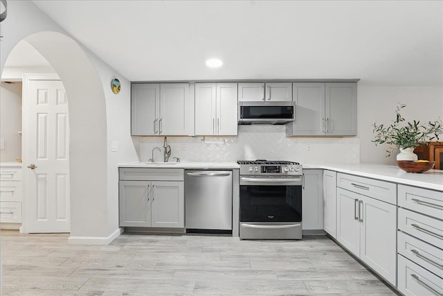 221 Terrace Ave, Jersey City, NJ 07307 - kitchen with appliances with stainless steel finishes, gray cabinetry, backsplash, light countertops, and recessed lighting