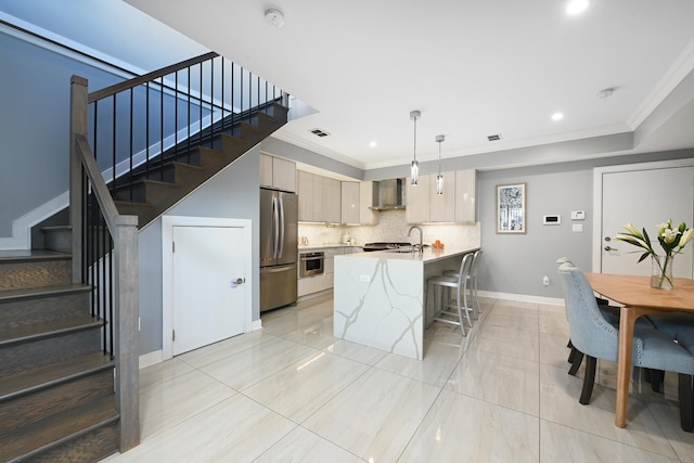 118 Irving St Unit 1, Jersey City, NJ 07307 - kitchen with appliances with stainless steel finishes, wall chimney exhaust hood, light countertops, a breakfast bar, and a peninsula