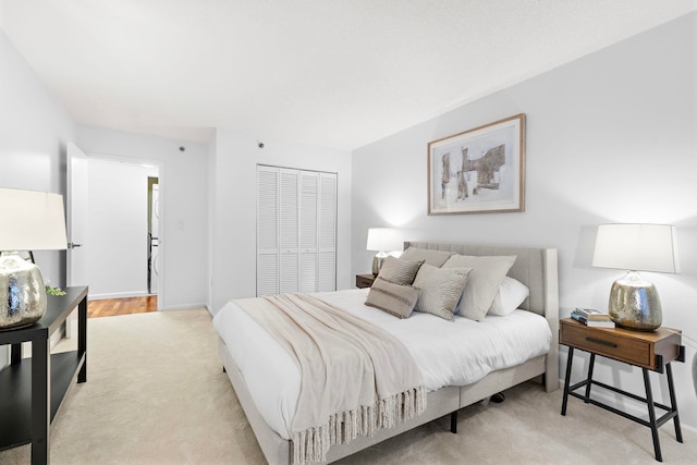 bedroom featuring baseboards, a closet, and light colored carpet