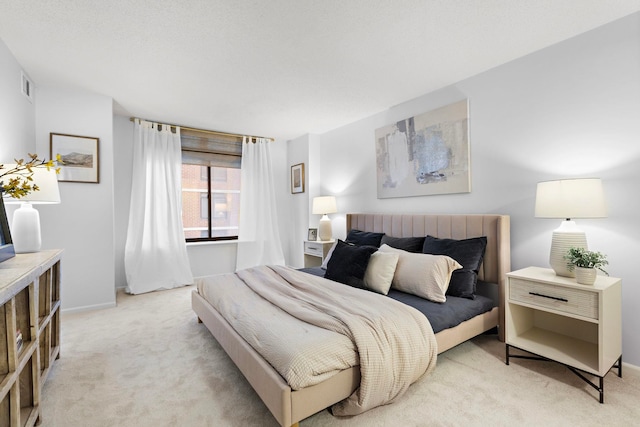 bedroom with light carpet, visible vents, and baseboards