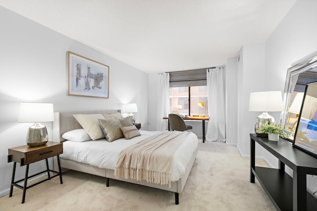 bedroom featuring light colored carpet and baseboards