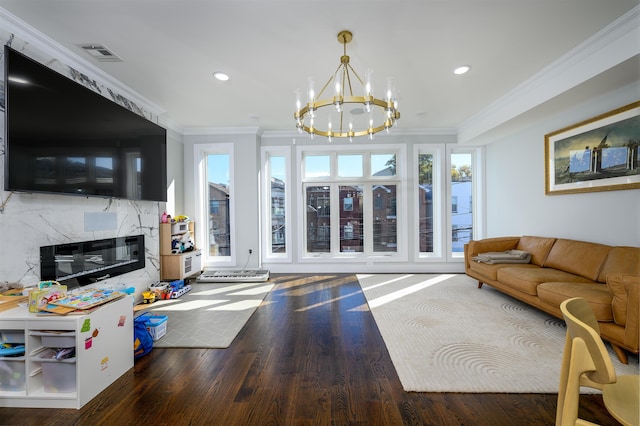 living room featuring a chandelier, a premium fireplace, wood-type flooring, and ornamental molding