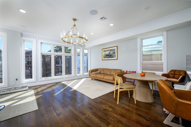 living room featuring plenty of natural light, dark hardwood / wood-style floors, ornamental molding, and an inviting chandelier