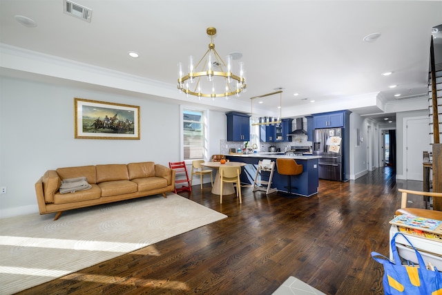 living room with crown molding, dark wood-type flooring, and a notable chandelier