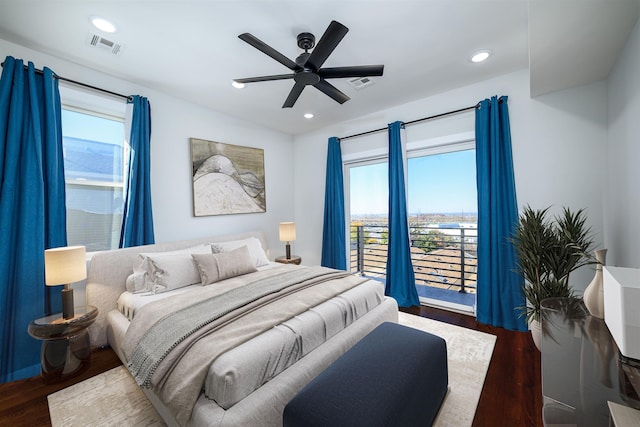 bedroom featuring multiple windows, dark hardwood / wood-style floors, and ceiling fan