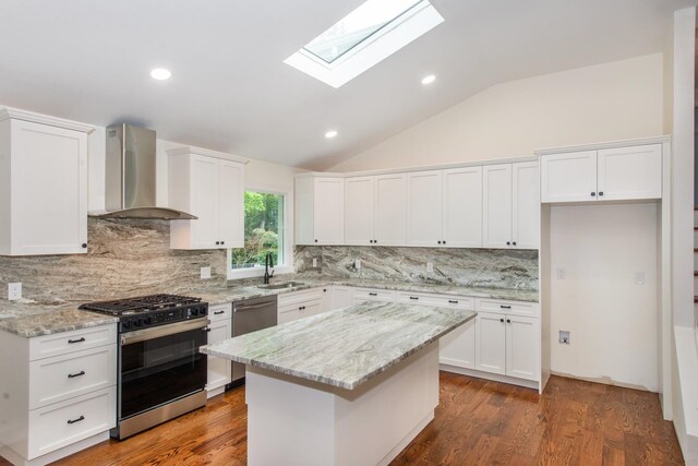 44 Grover Dr, Wayne, NJ 07470 - kitchen featuring appliances with stainless steel finishes, wall chimney range hood, a skylight, vaulted ceiling, and white cabinetry