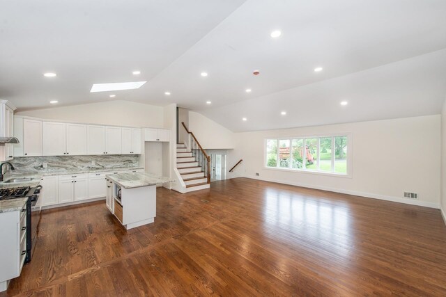 44 Grover Dr, Wayne, NJ 07470 - kitchen with lofted ceiling, light stone counters, decorative backsplash, a skylight, and a center island