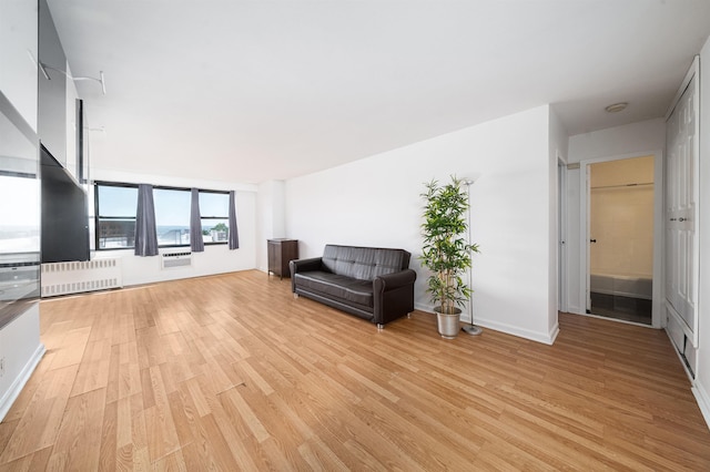 unfurnished room featuring light wood-type flooring and radiator heating unit