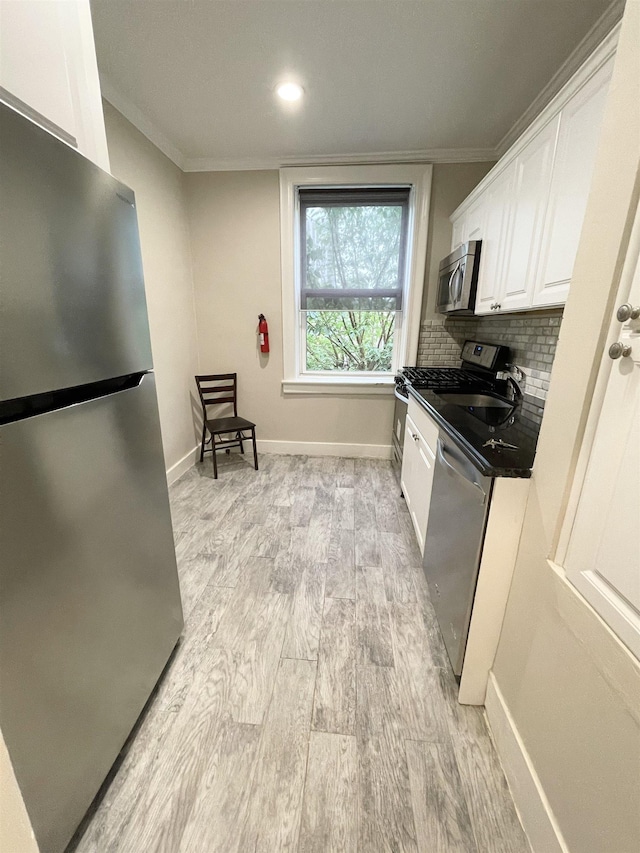 18 74th St Unit D5, North Bergen, NJ 07047 - kitchen with stainless steel appliances, white cabinetry, dark countertops, ornamental molding, and light wood finished floors