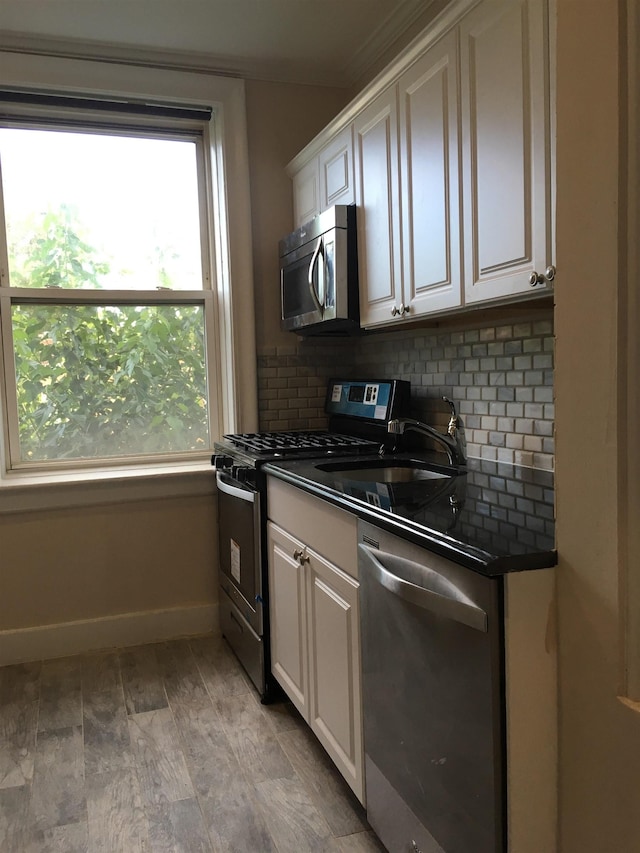 18 74th St Unit D5, North Bergen, NJ 07047 - kitchen with appliances with stainless steel finishes, healthy amount of natural light, dark countertops, and tasteful backsplash
