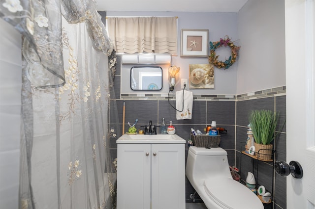 bathroom featuring vanity, toilet, and tile walls