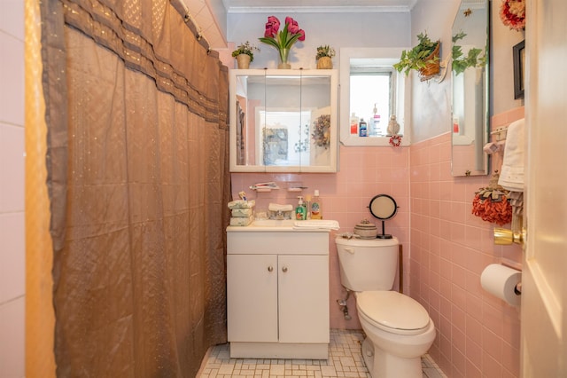 bathroom with vanity, tile patterned flooring, toilet, and tile walls