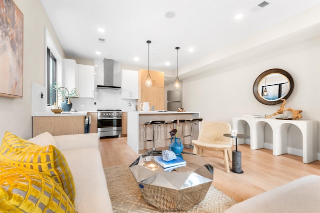 living room featuring sink and light hardwood / wood-style floors