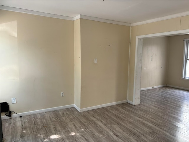 unfurnished room featuring hardwood / wood-style flooring and crown molding