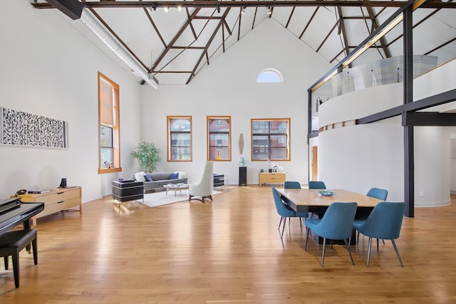 dining space featuring high vaulted ceiling, plenty of natural light, and hardwood / wood-style flooring