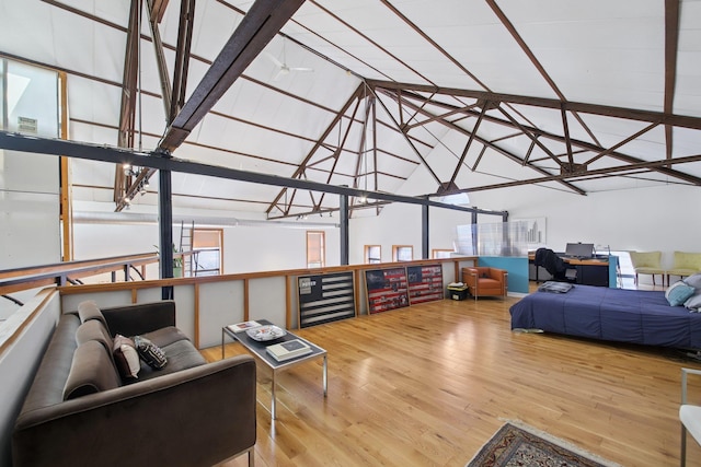 bedroom with beverage cooler, vaulted ceiling, and wood finished floors