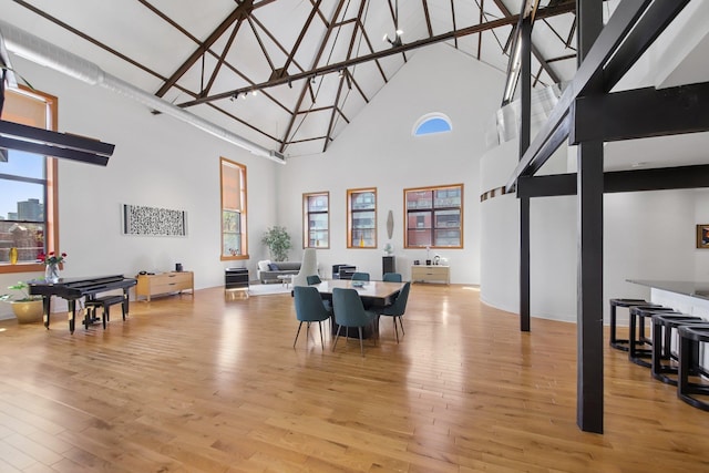 dining room featuring light wood-style flooring and a towering ceiling