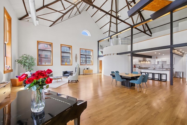 interior space featuring wood finished floors, high vaulted ceiling, and beamed ceiling