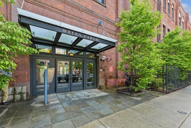 view of exterior entry with brick siding and french doors