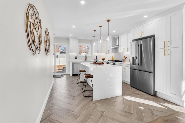 kitchen with a breakfast bar, stainless steel appliances, decorative light fixtures, a center island, and white cabinetry