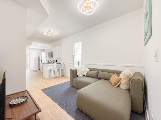 living area with baseboards and light wood finished floors