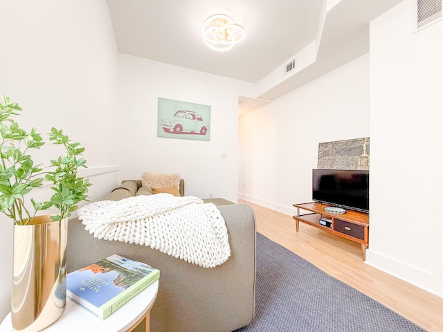 bedroom with baseboards, wood finished floors, and visible vents