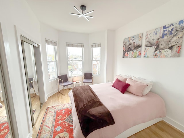 bedroom with light wood finished floors and baseboards
