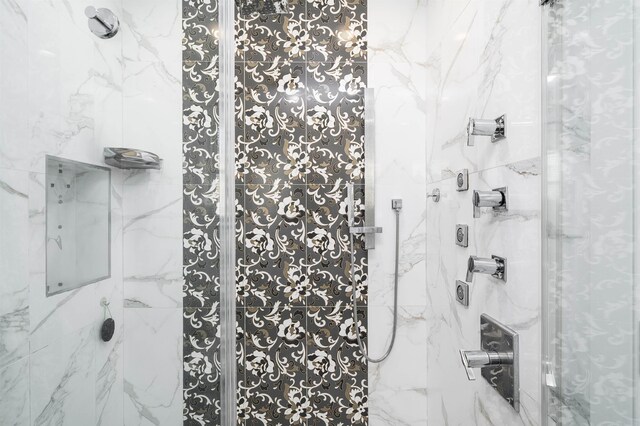 bathroom featuring a marble finish shower