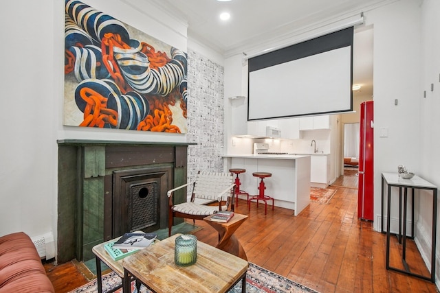 237 3rd St Unit 1, Jersey City, NJ 07302 - home theater room featuring wood-type flooring, a fireplace with flush hearth, and baseboard heating