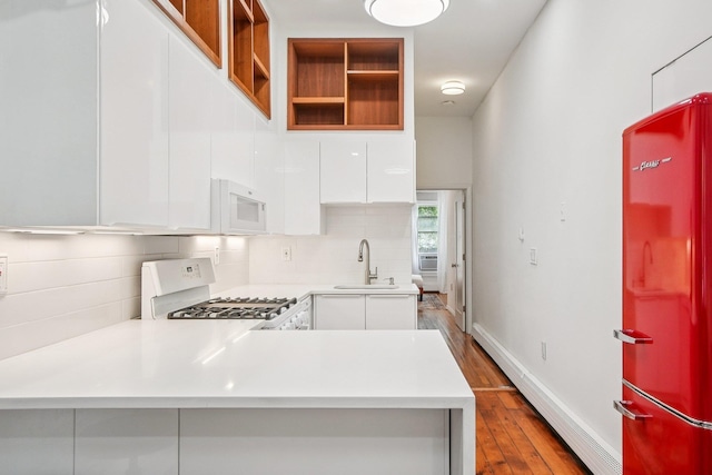 237 3rd St Unit 1, Jersey City, NJ 07302 - kitchen featuring white appliances, modern cabinets, white cabinetry, light countertops, and dark wood-style floors