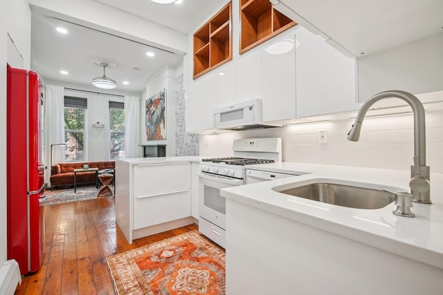 237 3rd St Unit 1, Jersey City, NJ 07302 - kitchen with white appliances, white cabinetry, light countertops, light wood-style floors, and backsplash