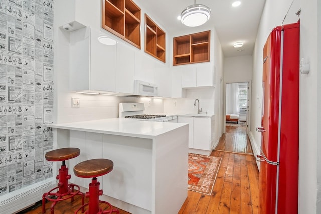 237 3rd St Unit 1, Jersey City, NJ 07302 - kitchen featuring white appliances, a peninsula, white cabinets, light wood-type flooring, and open shelves
