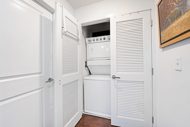 washroom with dark wood-style floors, laundry area, and stacked washing maching and dryer