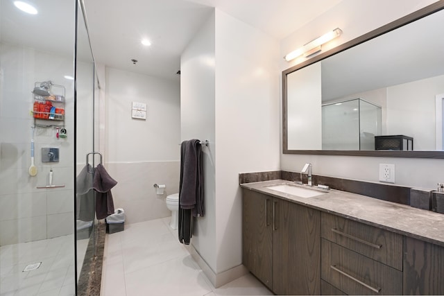 full bathroom with toilet, recessed lighting, tile walls, a shower stall, and vanity