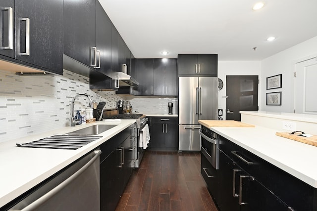 kitchen with a sink, stainless steel appliances, and dark cabinetry