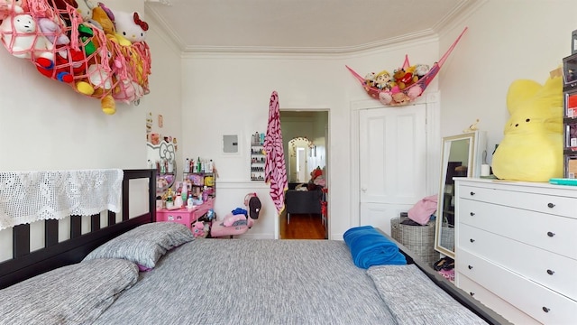 bedroom with a closet, wood-type flooring, and crown molding