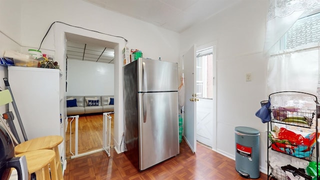 kitchen with stainless steel refrigerator and dark parquet flooring