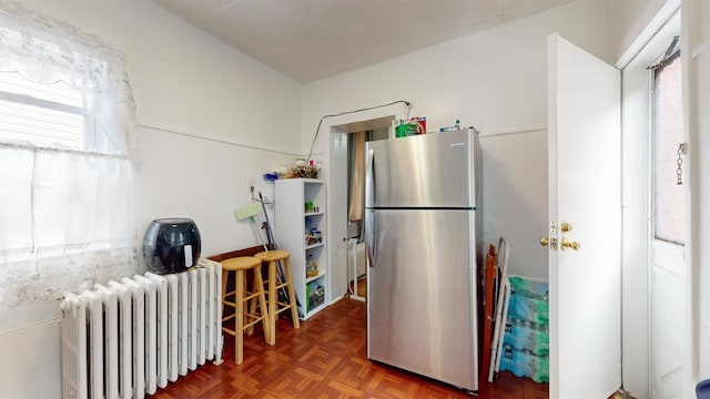 kitchen featuring stainless steel refrigerator, dark parquet flooring, and radiator heating unit