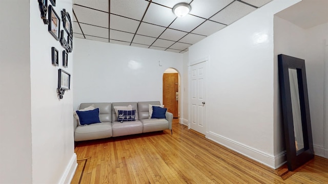 unfurnished living room featuring a drop ceiling and light hardwood / wood-style floors