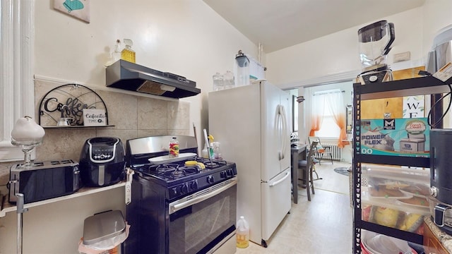 kitchen with tasteful backsplash, ventilation hood, white refrigerator, and stainless steel gas stove