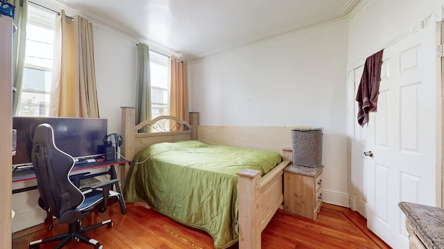 bedroom with hardwood / wood-style floors and ornamental molding