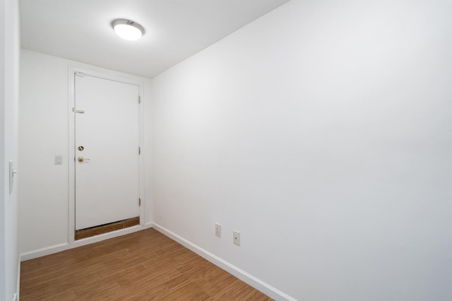 spare room featuring light wood-type flooring and baseboards