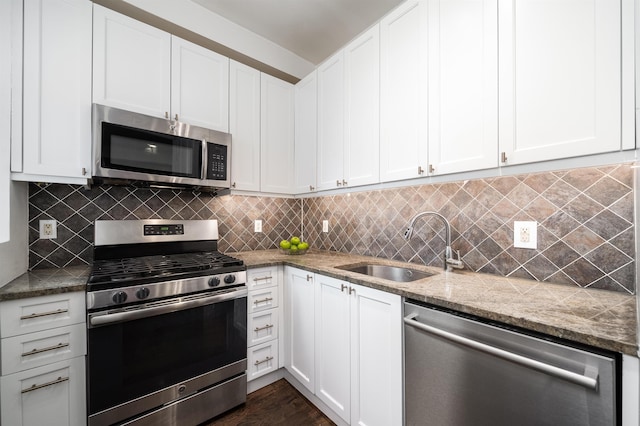 kitchen featuring stainless steel appliances, tasteful backsplash, a sink, and white cabinetry