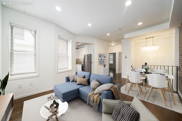 living room with baseboards, dark wood finished floors, a notable chandelier, and recessed lighting