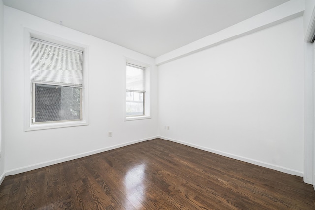 spare room with dark wood finished floors and baseboards